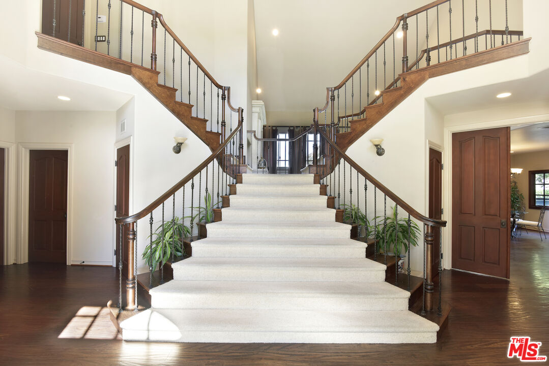 480 Westlake Boulevard Malibu, CA 90265 - Photo 4 of 36 a view of staircase with wooden floor and a chandelier