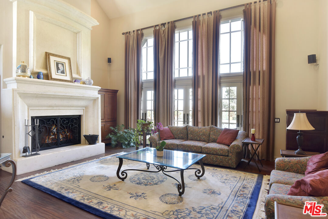 480 Westlake Boulevard Malibu, CA 90265 - Photo 8 of 36 a living room with furniture a rug a lamp and a fireplace