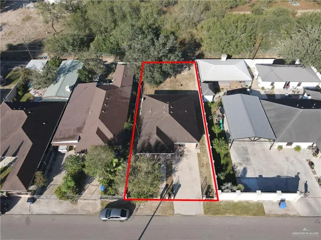 an aerial view of a house with a yard and seating space