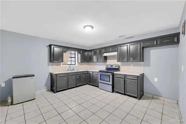 a large kitchen with a stove a refrigerator and a sink