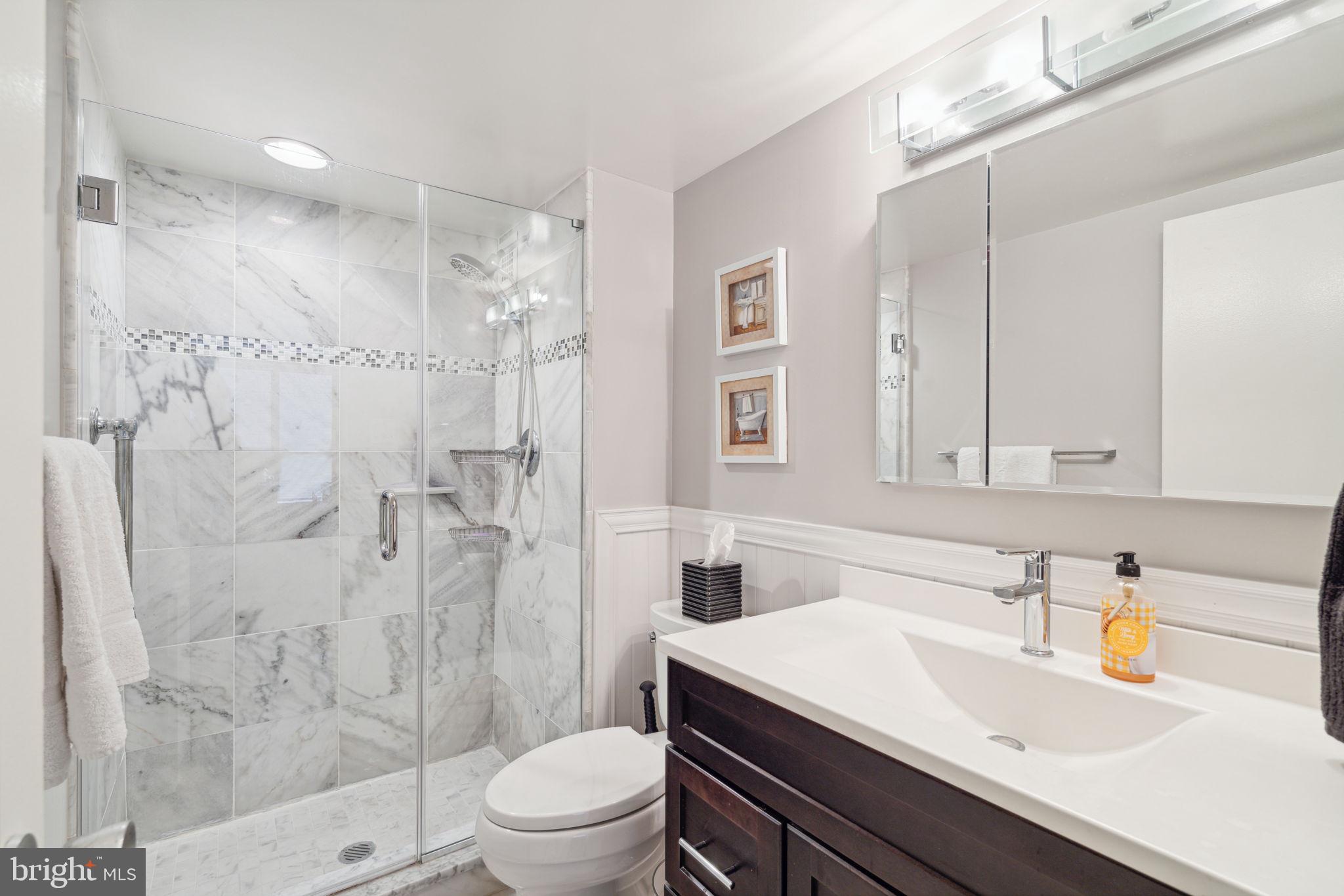 224-30 West Rittenhouse Square, Unit 1201 Philadelphia, PA 19103 - Photo 21 of 34 a bathroom with a sink toilet a mirror and shower
