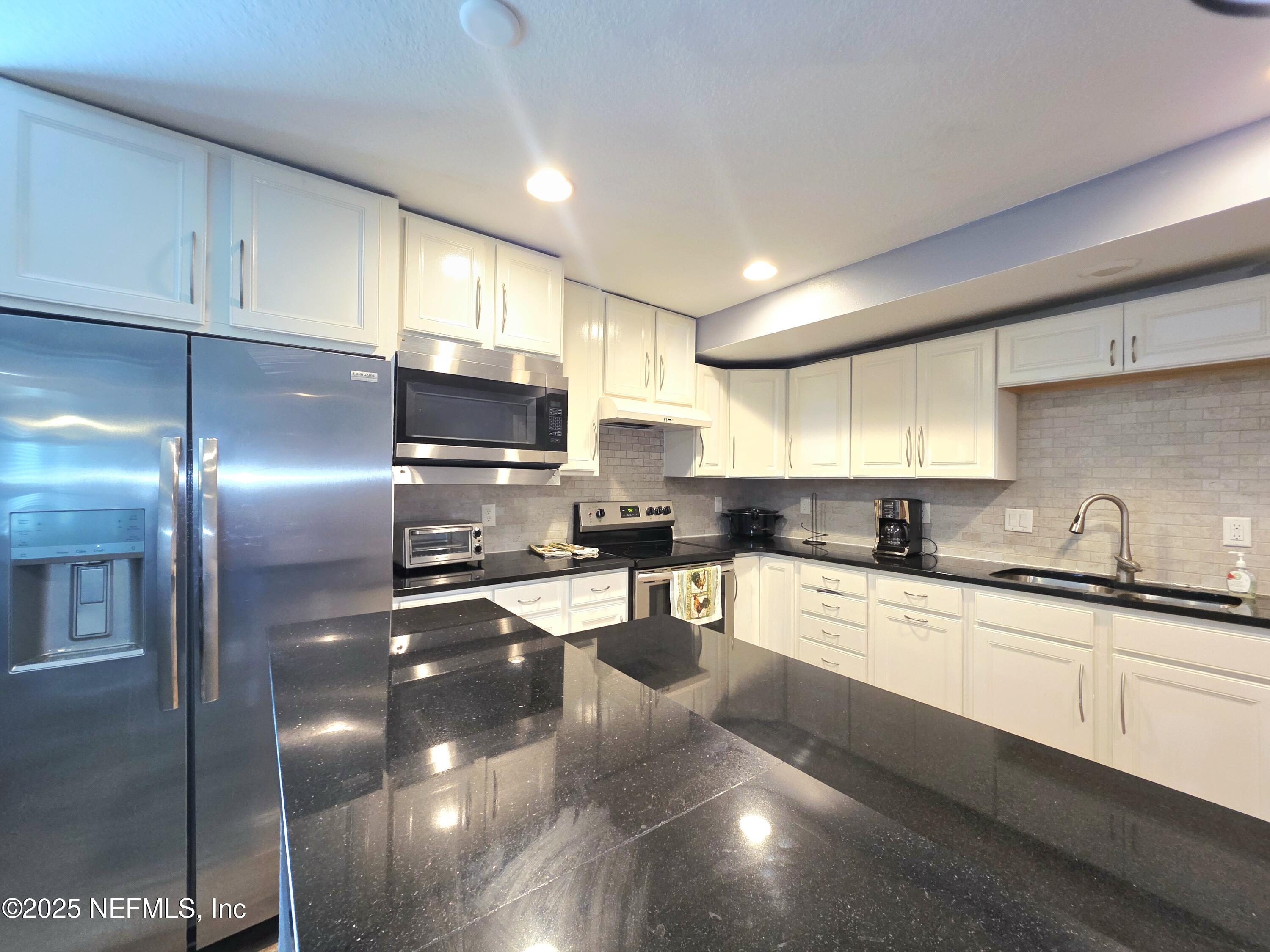 3065 Francis Road Jacksonville, FL 32209 - Photo 11 of 22 a kitchen with stainless steel appliances granite countertop a sink a stove and a refrigerator