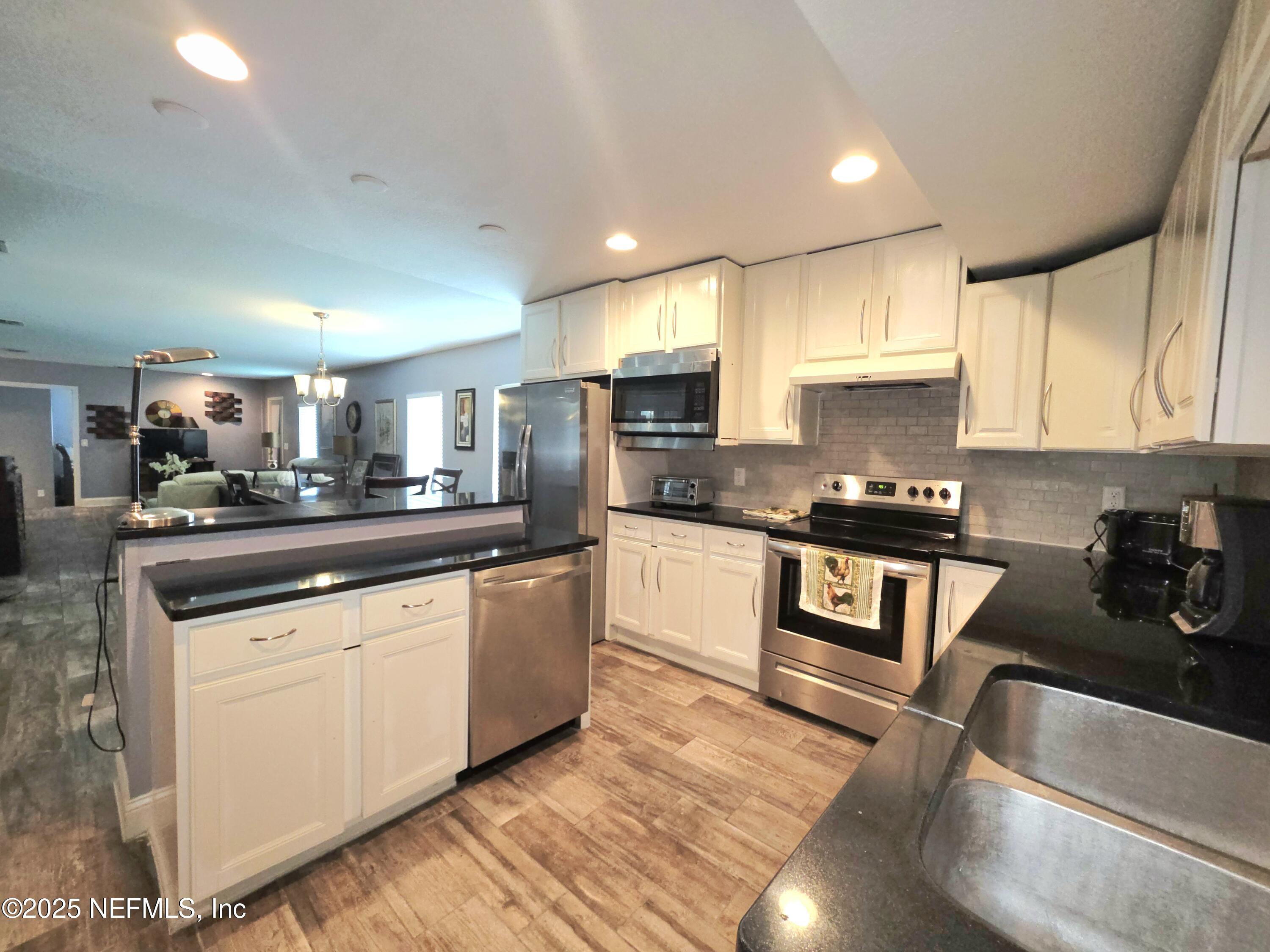 3065 Francis Road Jacksonville, FL 32209 - Photo 17 of 22 a kitchen with granite countertop a sink a counter top space cabinets and stainless steel appliances