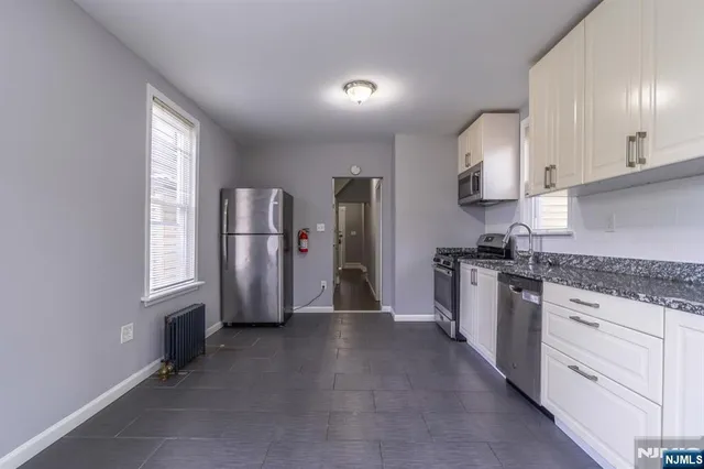 a kitchen with stainless steel appliances granite countertop a refrigerator and a stove top oven