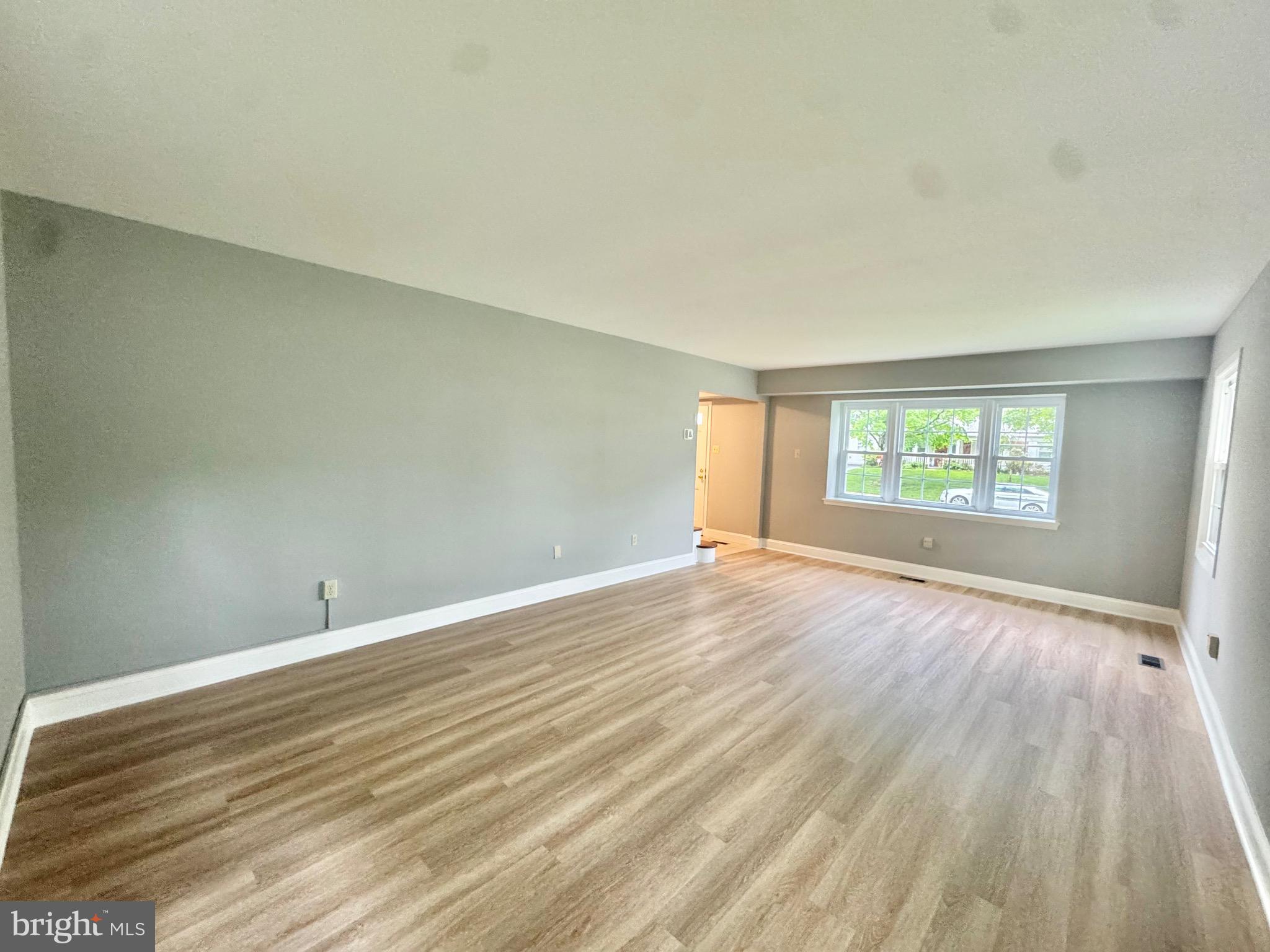 4908 Rocky Spring Lane Bowie, MD 20715 - Photo 3 of 36 a view of an empty room with wooden floor and a window