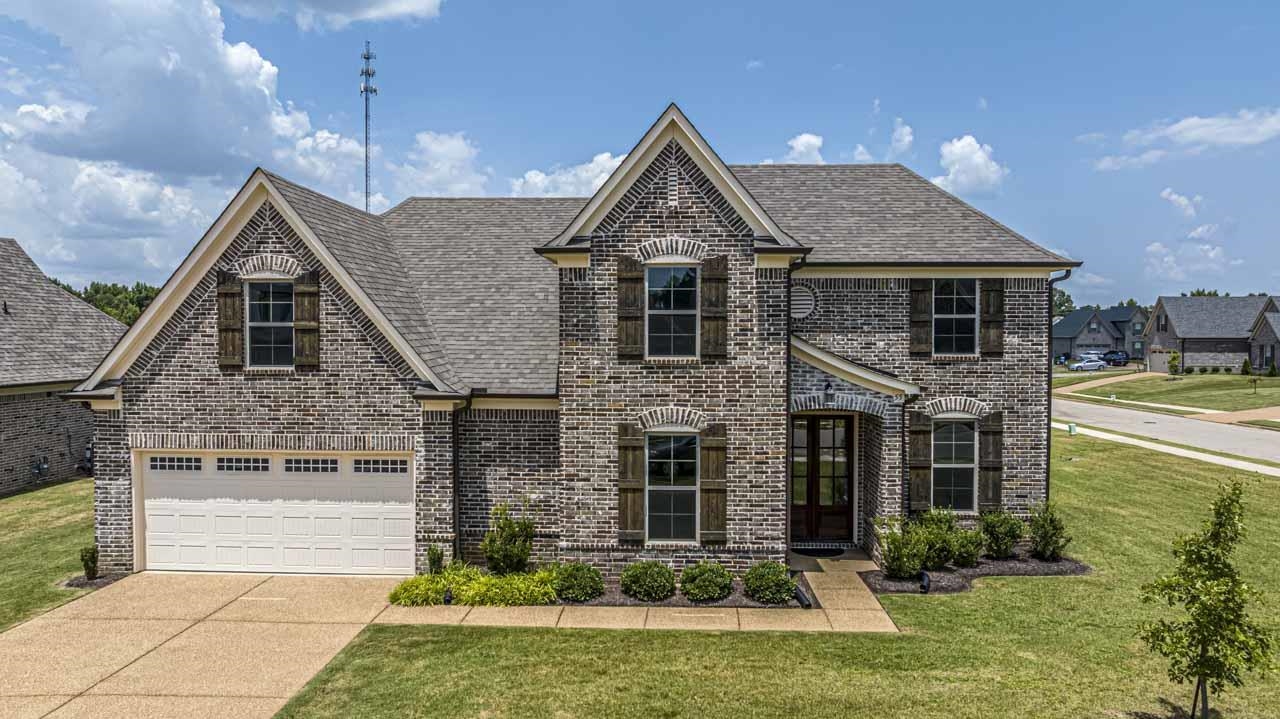 a front view of a house with a yard outdoor seating and garage
