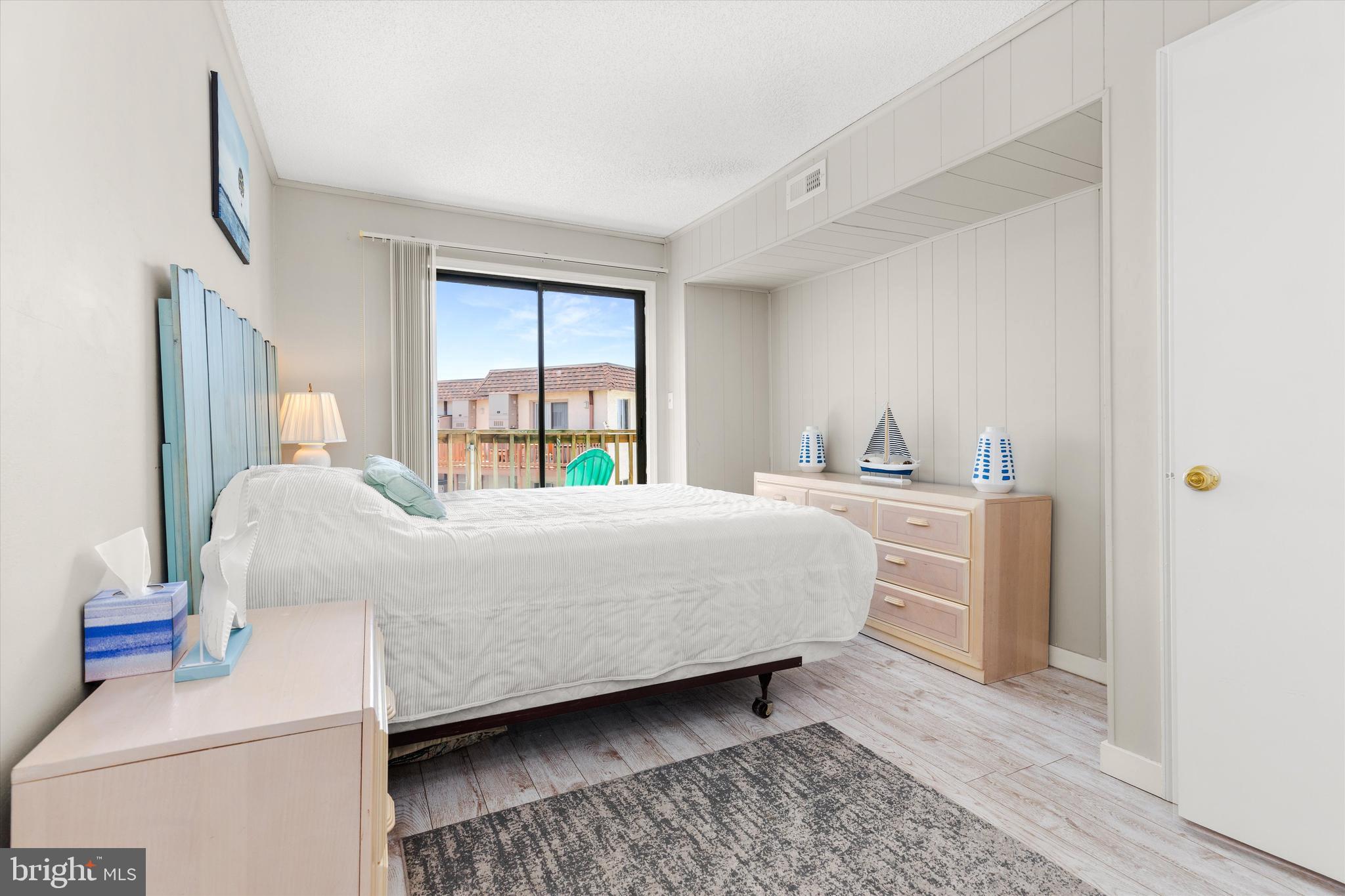 411 146th Street, Unit 332 Ocean City, MD 21842 - Photo 16 of 22 a bedroom with a bed and a large window