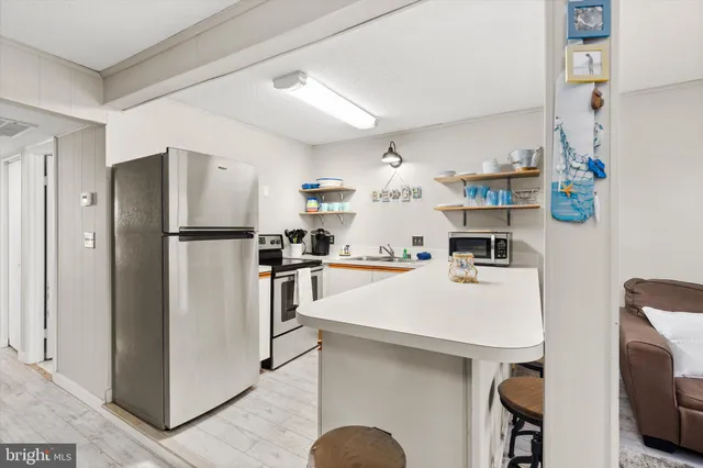 a kitchen with stainless steel appliances a refrigerator sink and microwave