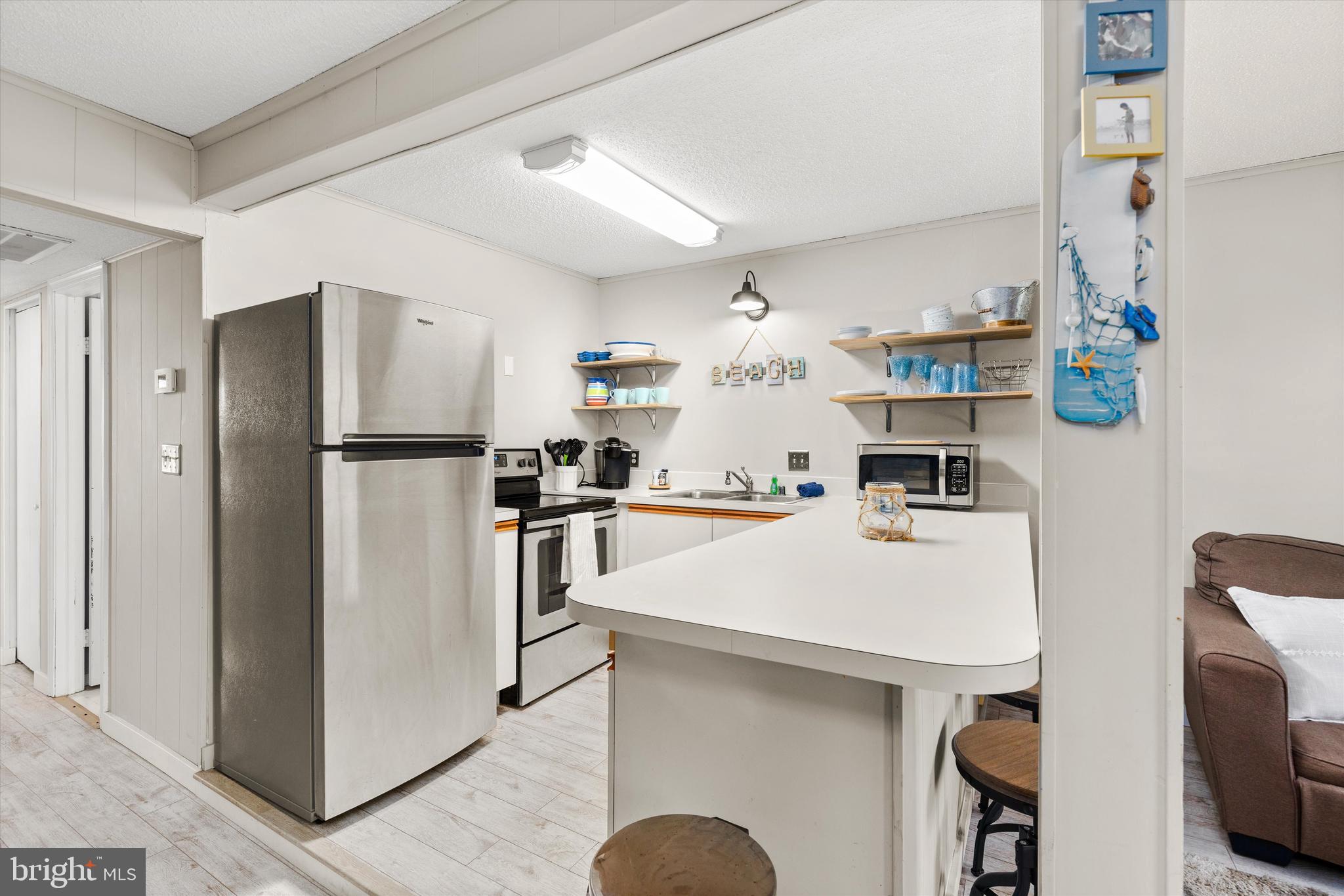 411 146th Street, Unit 332 Ocean City, MD 21842 - Photo 9 of 22 a kitchen with stainless steel appliances a refrigerator sink and microwave