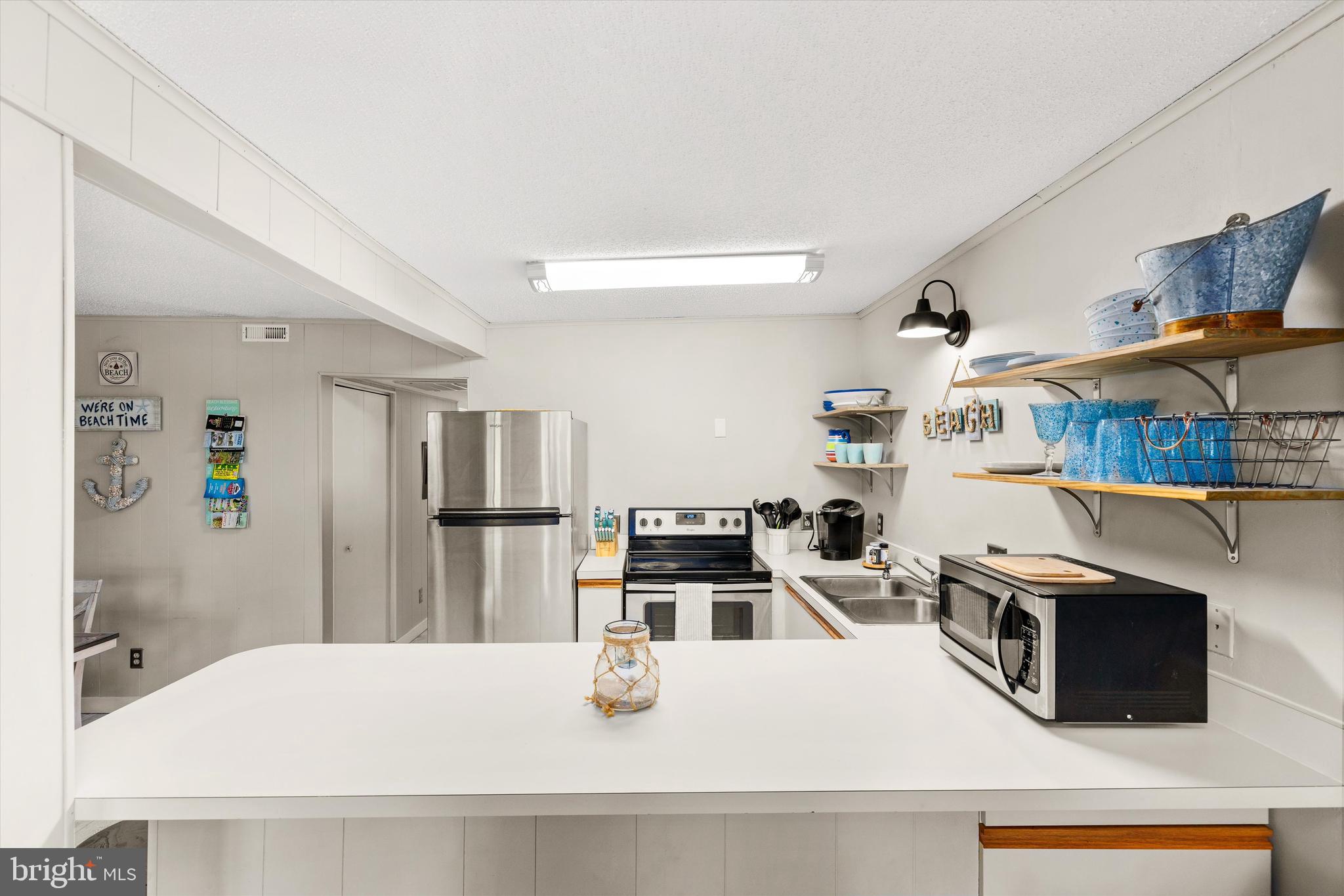 411 146th Street, Unit 332 Ocean City, MD 21842 - Photo 10 of 22 a kitchen with stainless steel appliances granite countertop a refrigerator and a stove