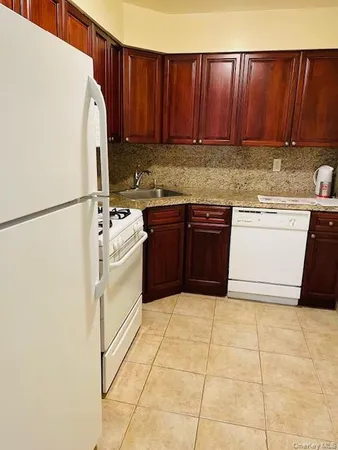 a kitchen with a white stove top oven and cabinets