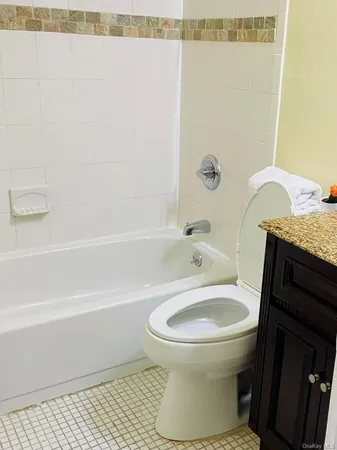 a bathroom with a granite countertop toilet and a shower