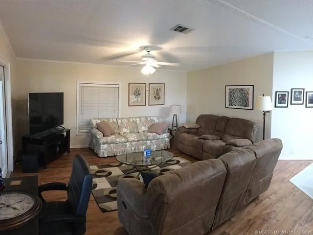 a living room with furniture a flat screen tv and kitchen view