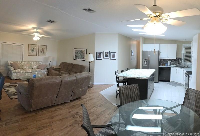 14514 Southwest Rake Drive Indiantown, FL 34956 - Photo 2 of 10 a living room with furniture and a chandelier