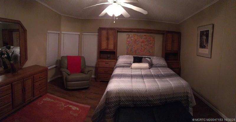 14514 Southwest Rake Drive Indiantown, FL 34956 - Photo 7 of 10 a bedroom with a bed and wooden floor