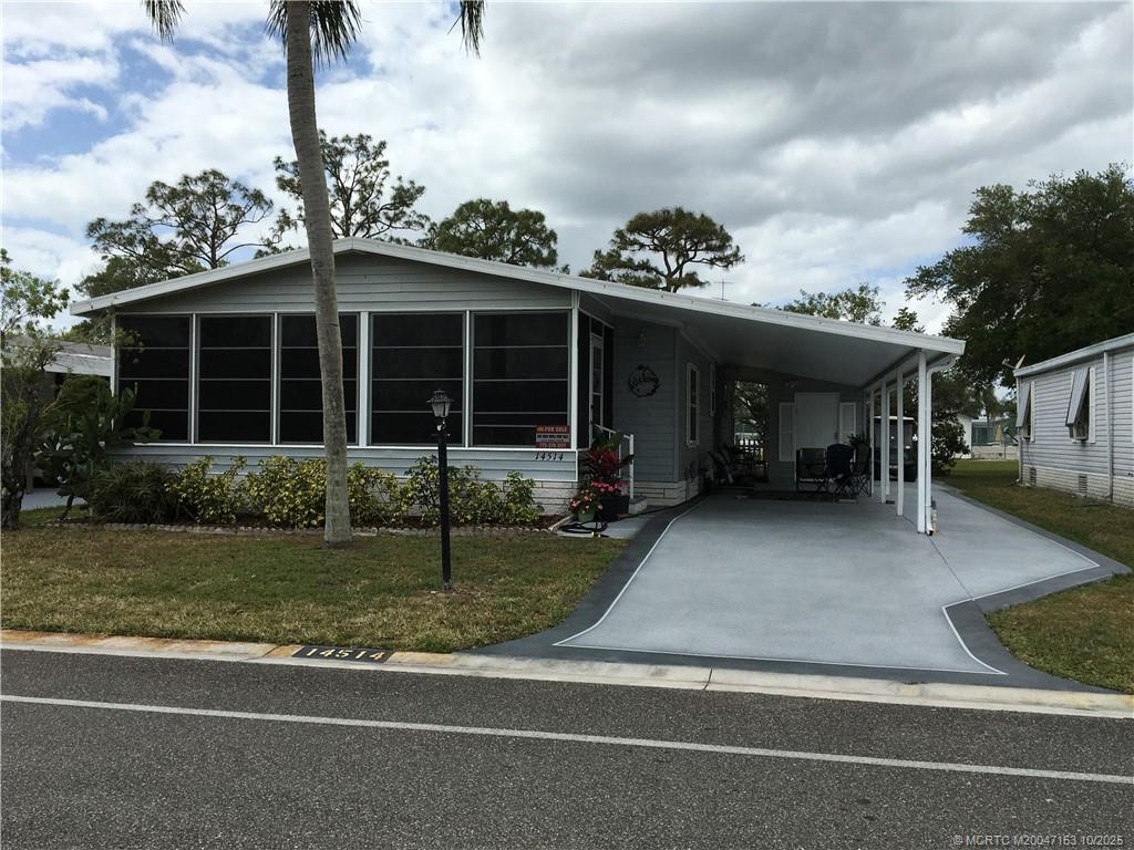 14514 Southwest Rake Drive Indiantown, FL 34956 - Photo 9 of 10 a view of a house that has a bunch of plants and large tree