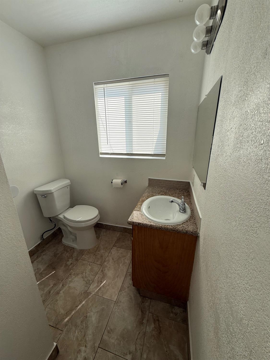 501 Rotan Avenue Madera, CA 93637 - Photo 7 of 23 a bathroom with a sink toilet and a mirror