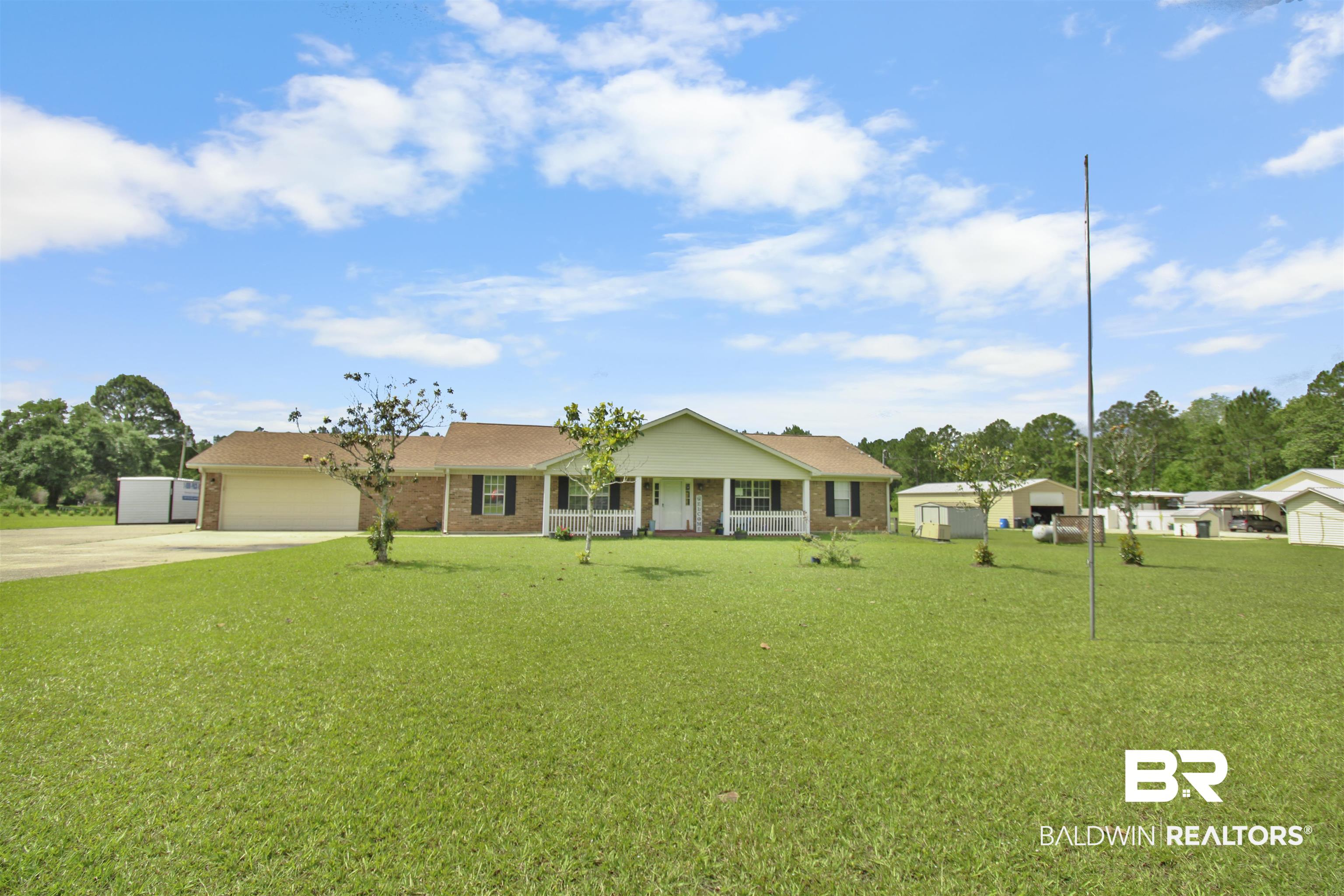 26850 Timber Lane Elberta, AL 36530 - Photo 25 of 33 Single story home featuring concrete driveway, brick siding, a front lawn, a garage, and a porch