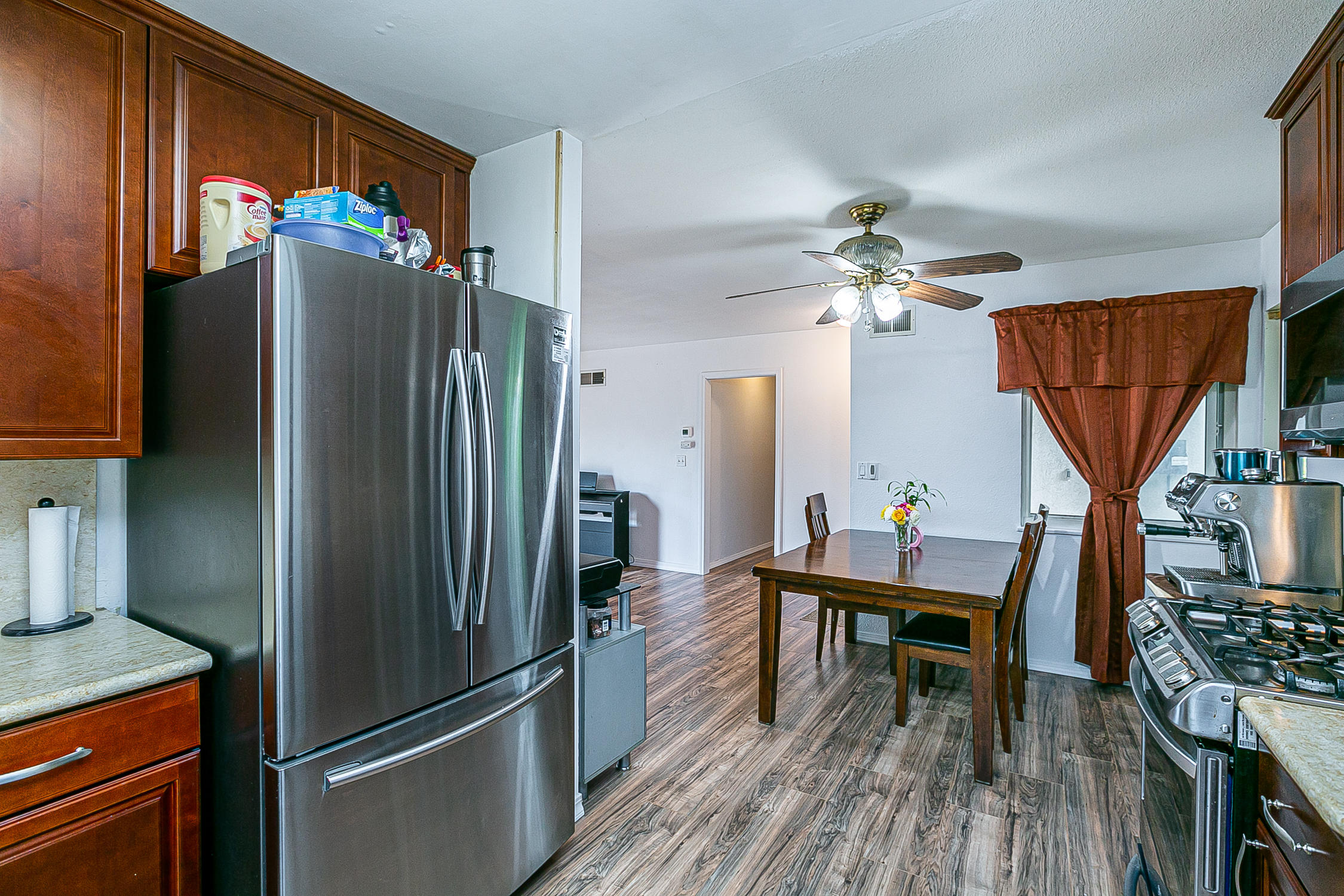 321 South T Street Lompoc, CA 93436 - Photo 13 of 29 a kitchen with stainless steel appliances a refrigerator a stove a sink and a dining table with wooden floor