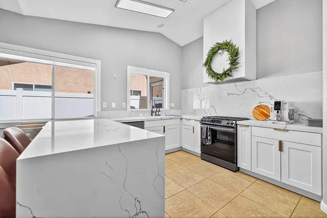 a kitchen with stainless steel appliances a stove a sink and a microwave