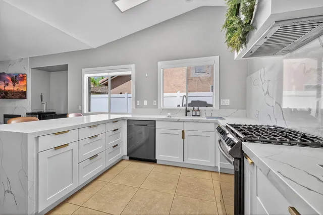 a kitchen with cabinets appliances a sink and a window