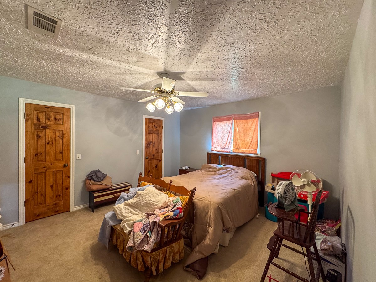 37 Archie Road Huntsville, TX 77320 - Photo 11 of 40 a bedroom with a bed and a chandelier