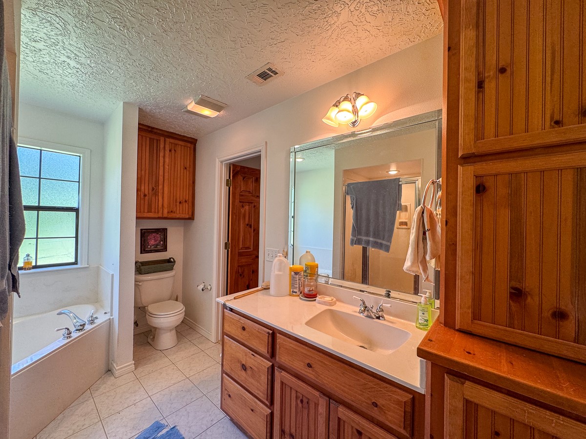 37 Archie Road Huntsville, TX 77320 - Photo 12 of 40 a bathroom with a sink a toilet and a large mirror