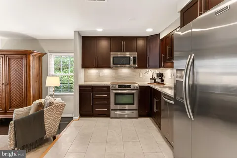 a kitchen with stainless steel appliances kitchen island granite countertop a refrigerator and a stove top oven