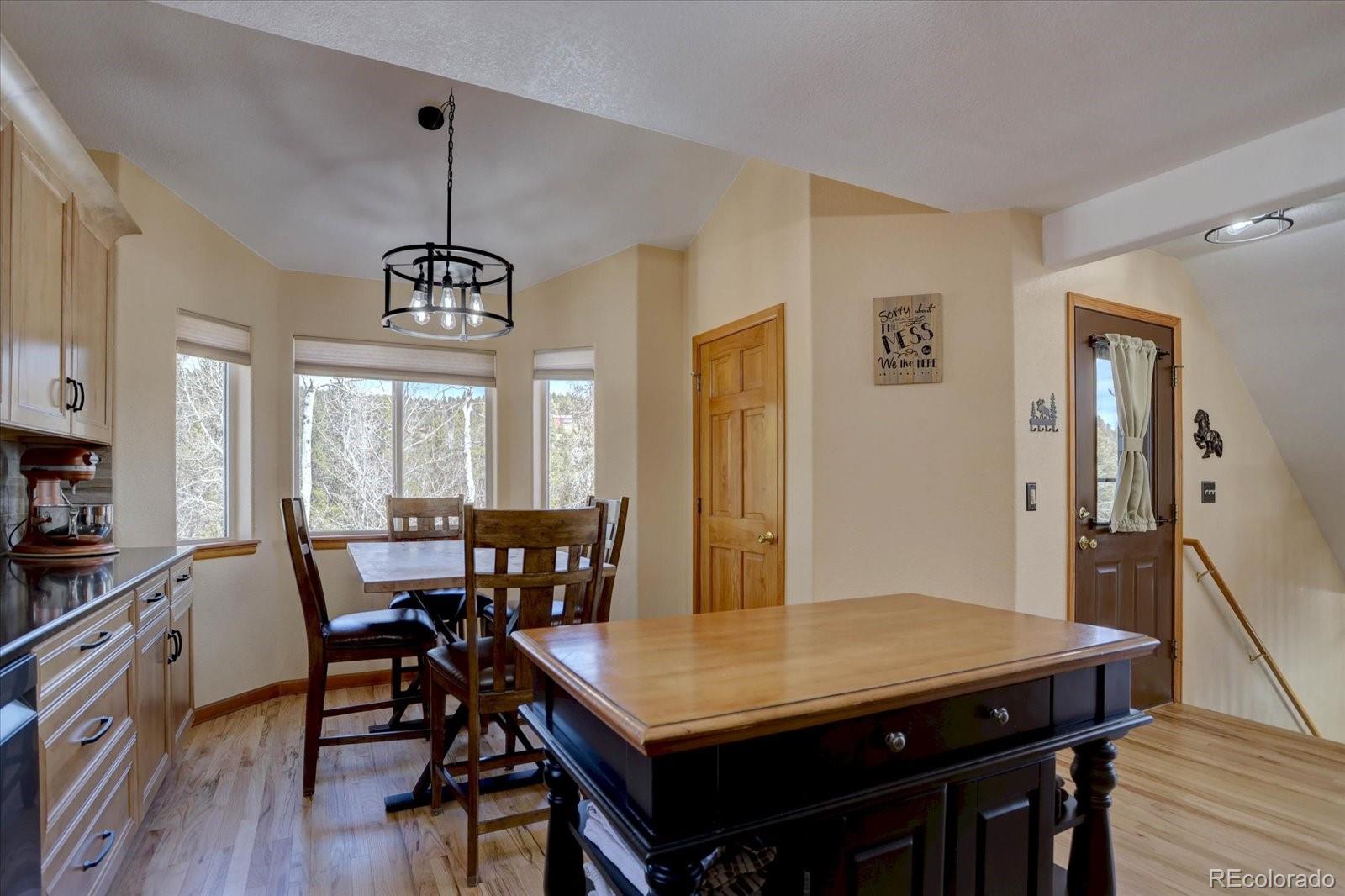 10438 Sunlight Lane Conifer, CO 80433 - Photo 16 of 48 a view of a dining room with furniture window and wooden floor