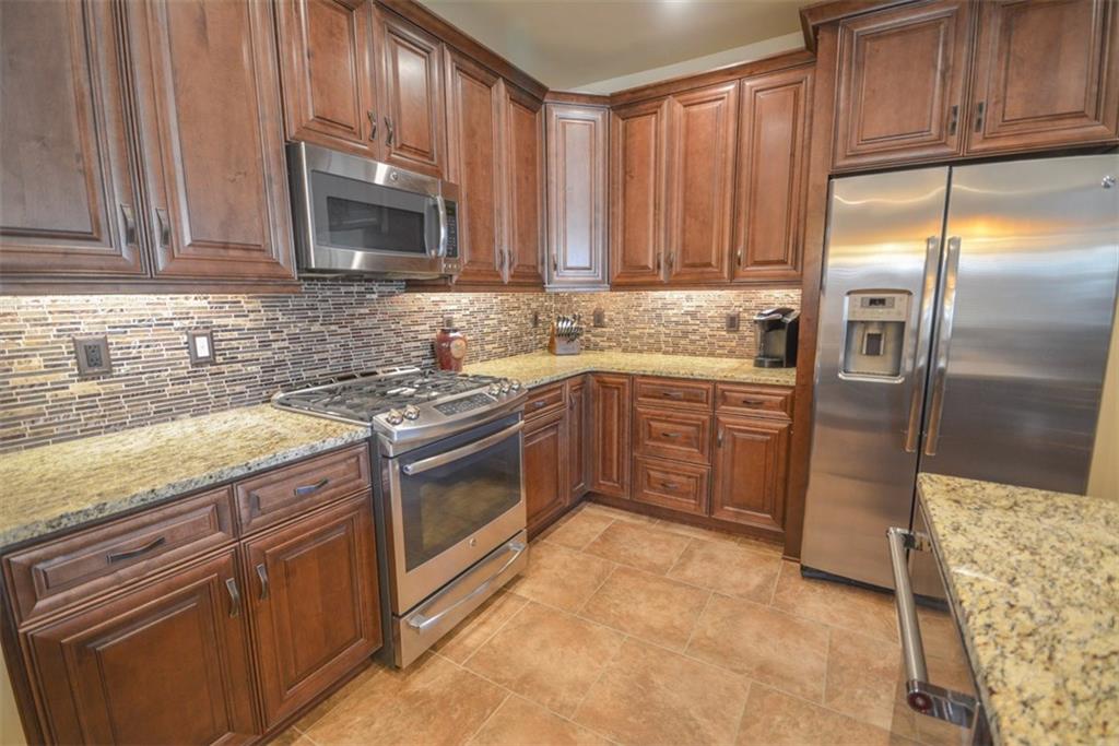 835 Independence Road, Unit 6B Keystone, CO 80435 - Photo 18 of 30 a kitchen with stainless steel appliances granite countertop a stove a sink dishwasher and a refrigerator with wooden cabinets
