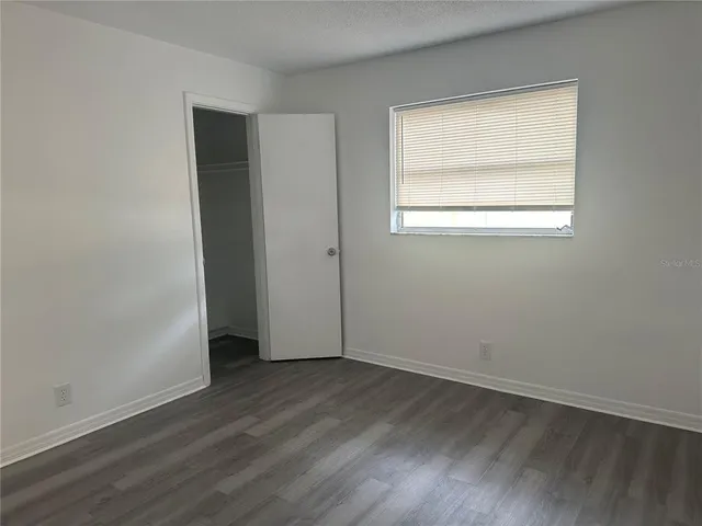 an empty room with wooden floor and a window