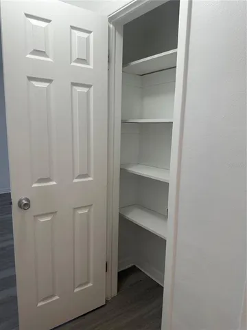 a view of walk in closet with empty racks