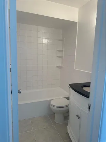 a bathroom with a granite countertop toilet a sink and shower