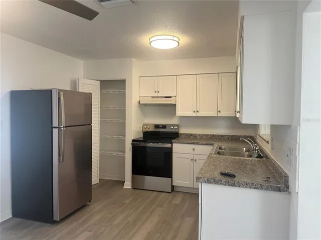 a kitchen with a refrigerator stove and cabinets