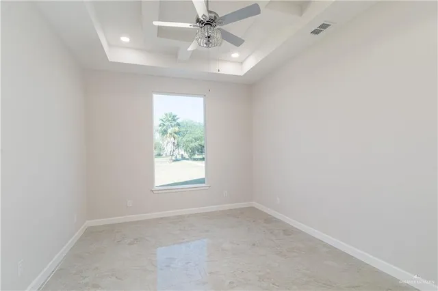 an empty room with a window and a fan