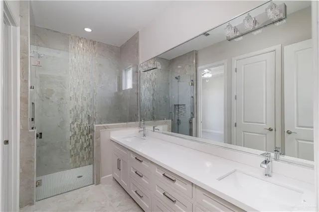 a bathroom with a double vanity sink mirror and shower