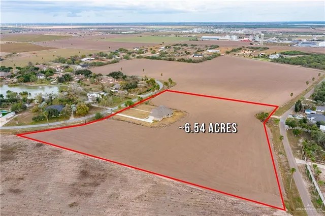 an aerial view of ocean and residential houses with outdoor space