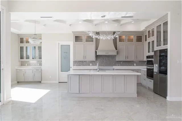 a large white kitchen with cabinets and stainless steel appliances