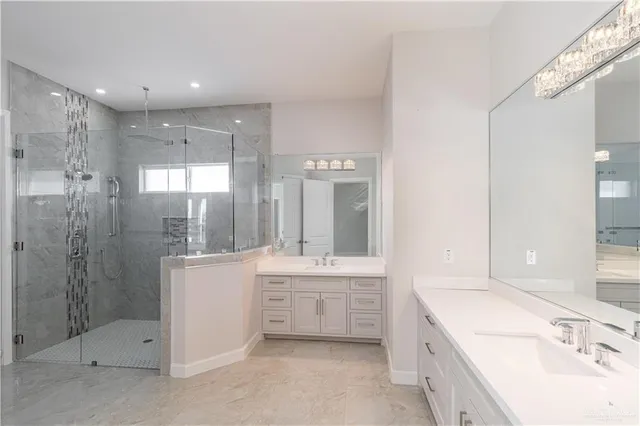 a bathroom with a double vanity sink mirror and shower