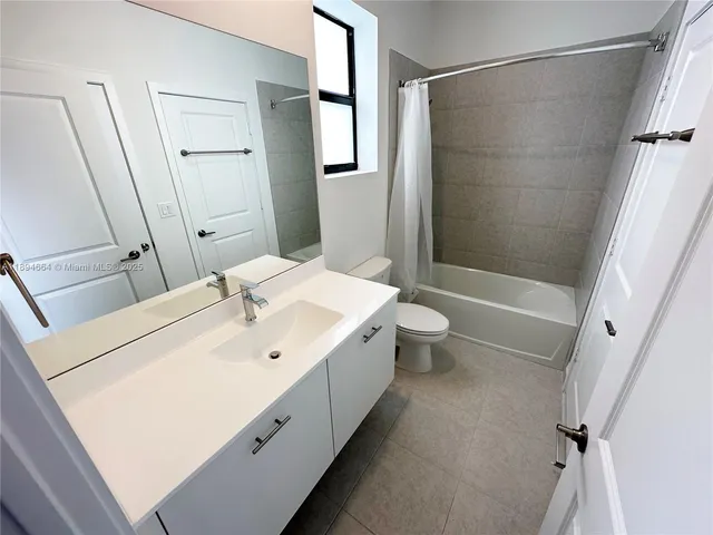 a bathroom with a double vanity sink toilet and shower