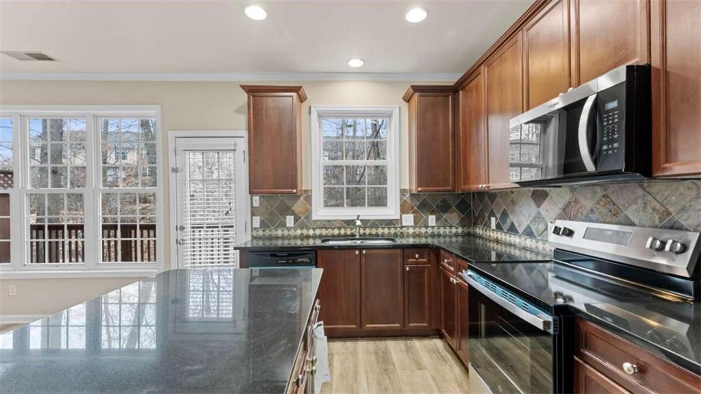 2620 Ridge Run Trail Duluth, GA 30097 - Photo 12 of 34 a kitchen with stainless steel appliances granite countertop a stove a sink dishwasher and cabinets with wooden floor
