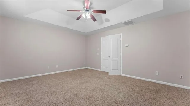 an empty room with a ceiling fan and a fan