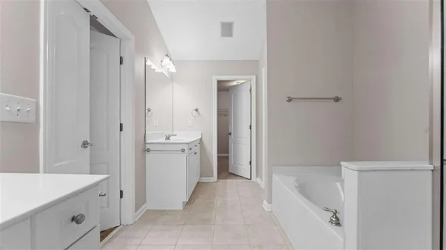 a bathroom with a tub sink and mirror