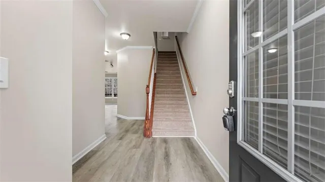 a view of a hallway with wooden floor and stairs
