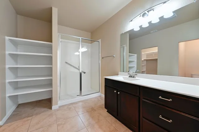 a spacious bathroom with a double vanity sink a and a mirror