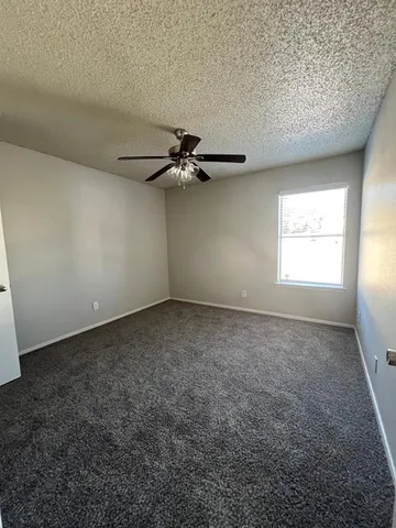 a view of a livingroom with a ceiling fan and window