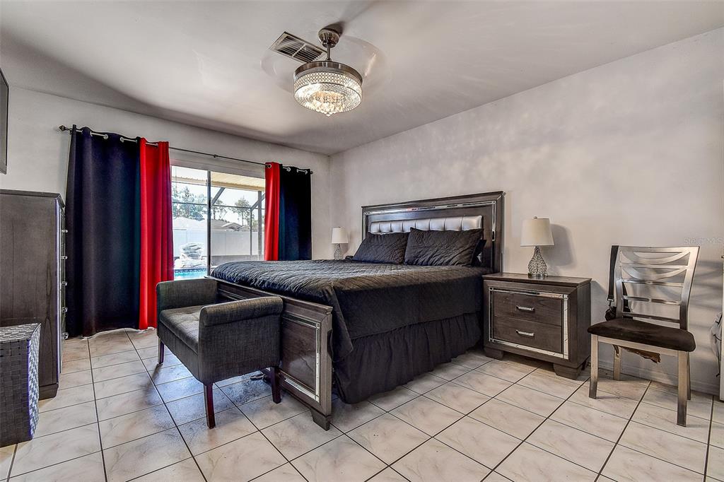 10440 Laval Street Spring Hill, FL 34608 - Photo 29 of 44 a bedroom with a bed and a chandelier