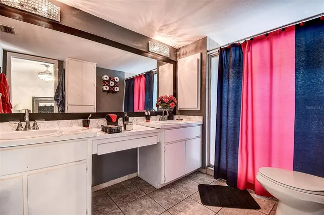 a bathroom with a granite countertop sink a toilet and a mirror