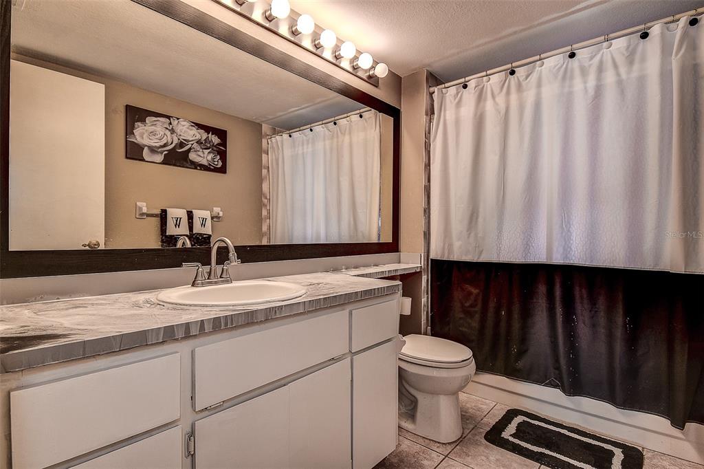 10440 Laval Street Spring Hill, FL 34608 - Photo 31 of 44 a bathroom with a granite countertop sink a toilet and a mirror