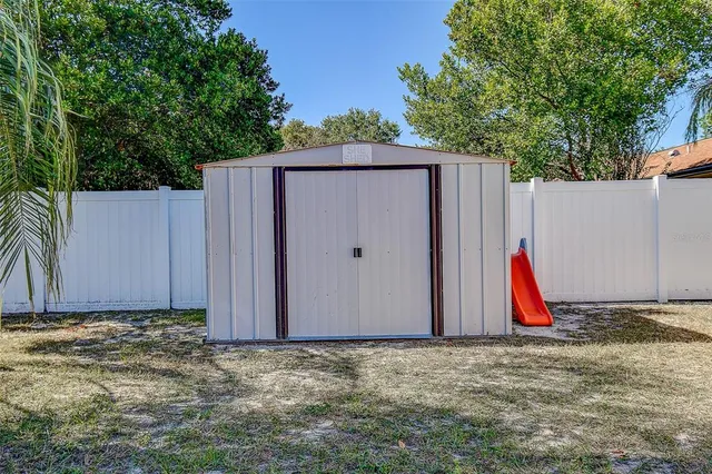 a view of a backyard with space and wooden fence